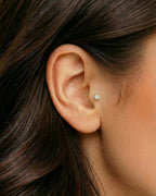 Altın renkli 6 mm tektaş flatback piercingin tragus ve kıkırdakta duruşu.