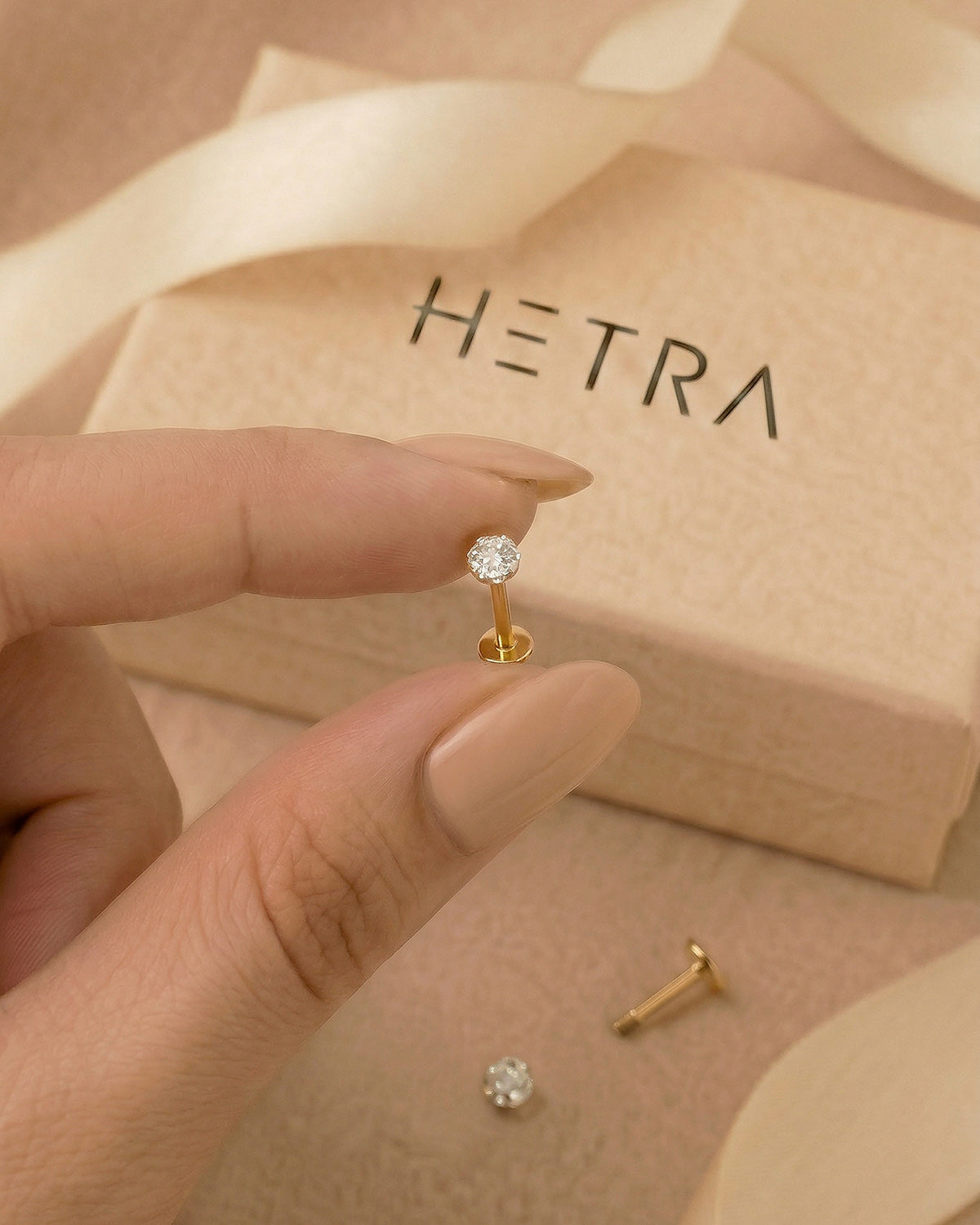 Altın renkli 316L cerrahi çelik 6 mm toplu flatback tragus piercing tasarımın elde duruşu.