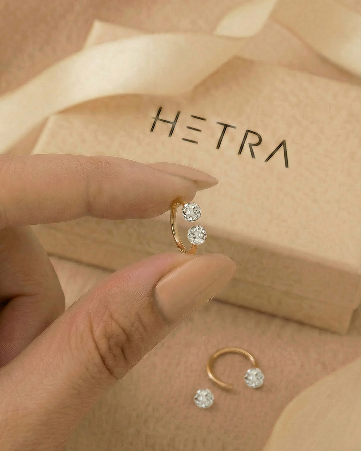 Altın renkli 316L cerrahi çelik 6 mm zirkon taşlı yarım halka piercing tasarımın elde duruşu.