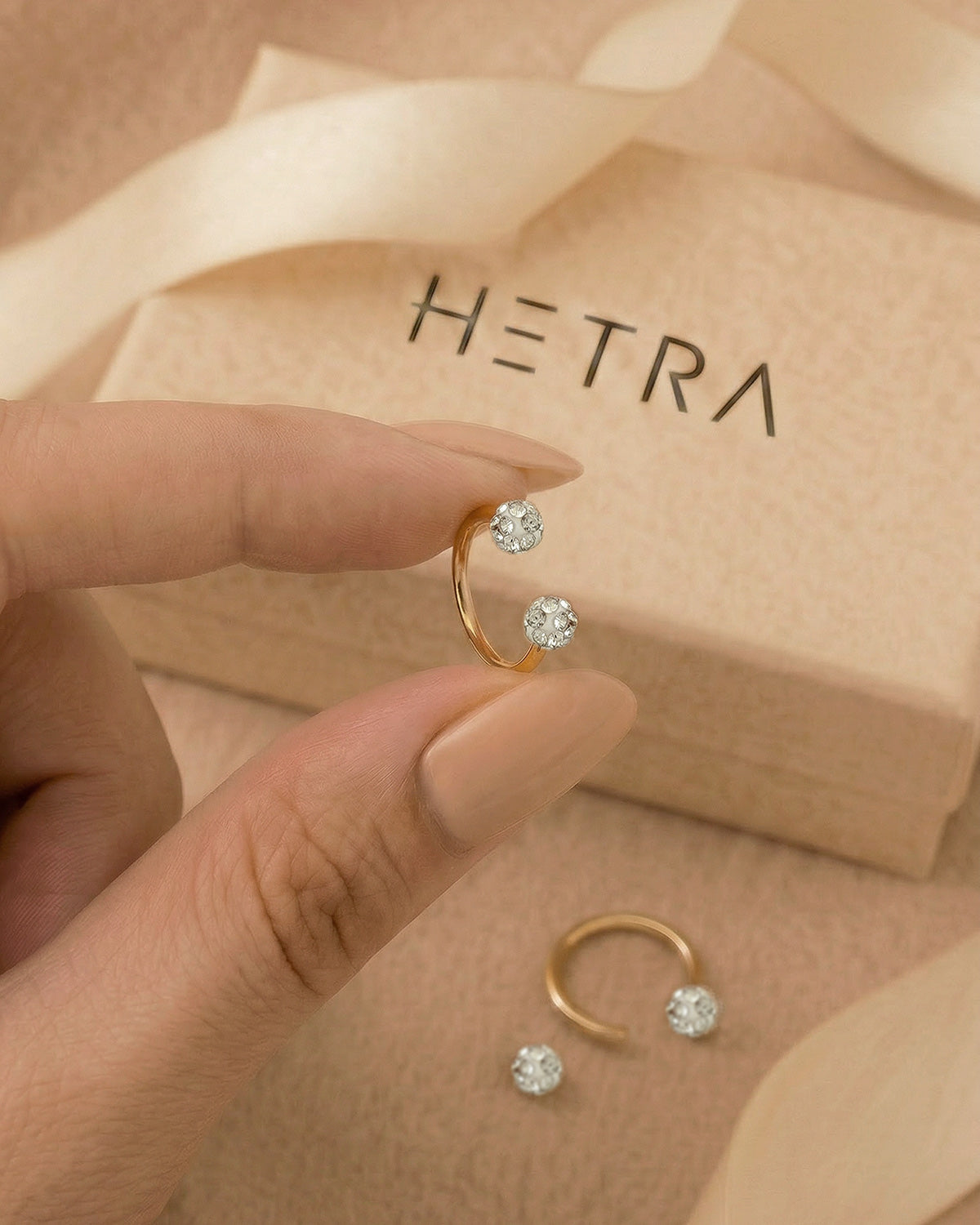 Altın renkli 316L cerrahi çelik 8 mm zirkon taşlı yarım halka piercing tasarımın elde duruşu.