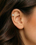 Altın renkli gümüş detaylı yonca zirkon taşlı halka piercingin helix ve kıkırdak bölgesinde duruşu.