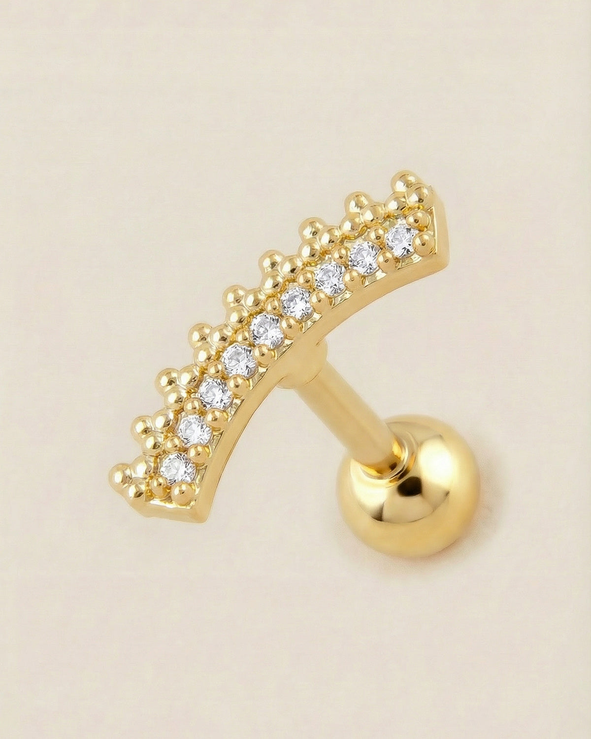 Altın renkli 316L cerrahi çelik kavisli zirkon taşlı tragus piercing tasarımı.