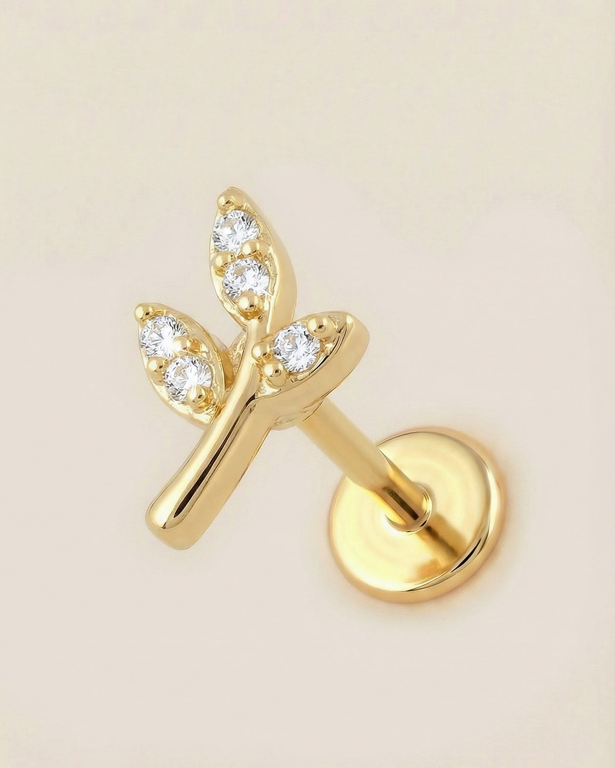 Altın renkli 316L cerrahi çelik minimal yaprak formlu flatback piercing tasarımı.