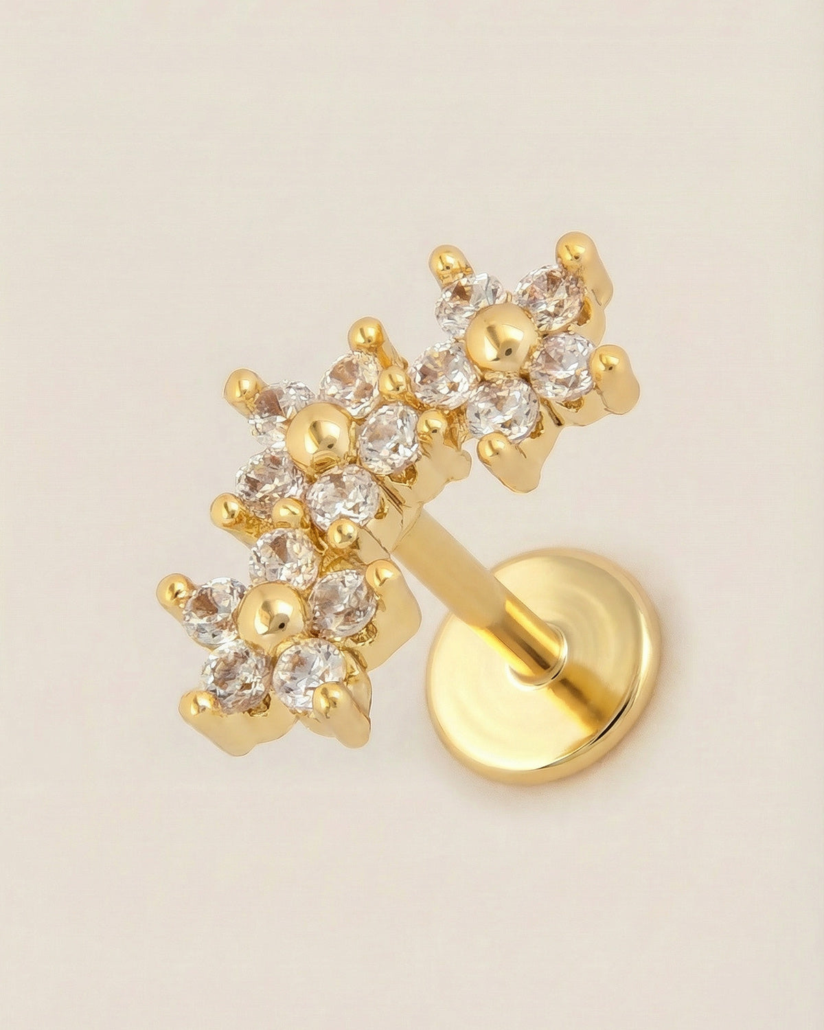Altın renkli 316L cerrahi çelik üçlü çiçek zirkon taşlı flatback piercing tasarımı.