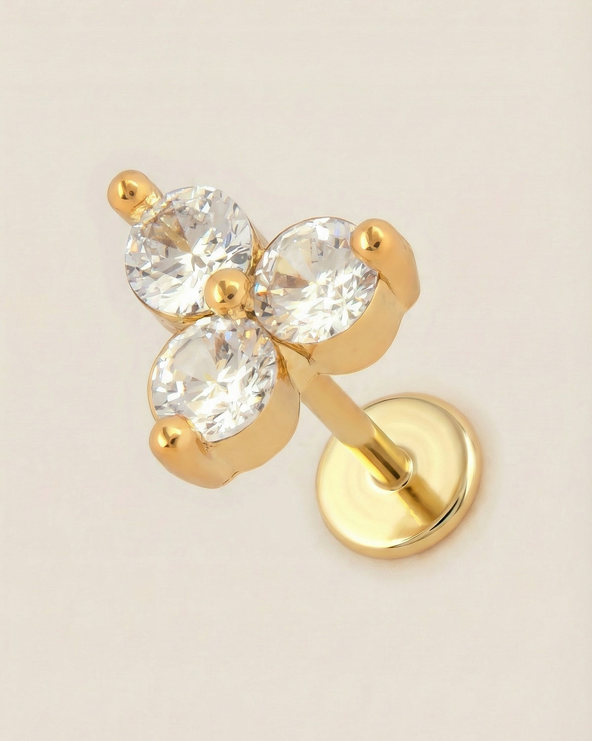 Altın renkli 316L cerrahi çelik üçlü taşlı trinity flatback piercing tasarımı.