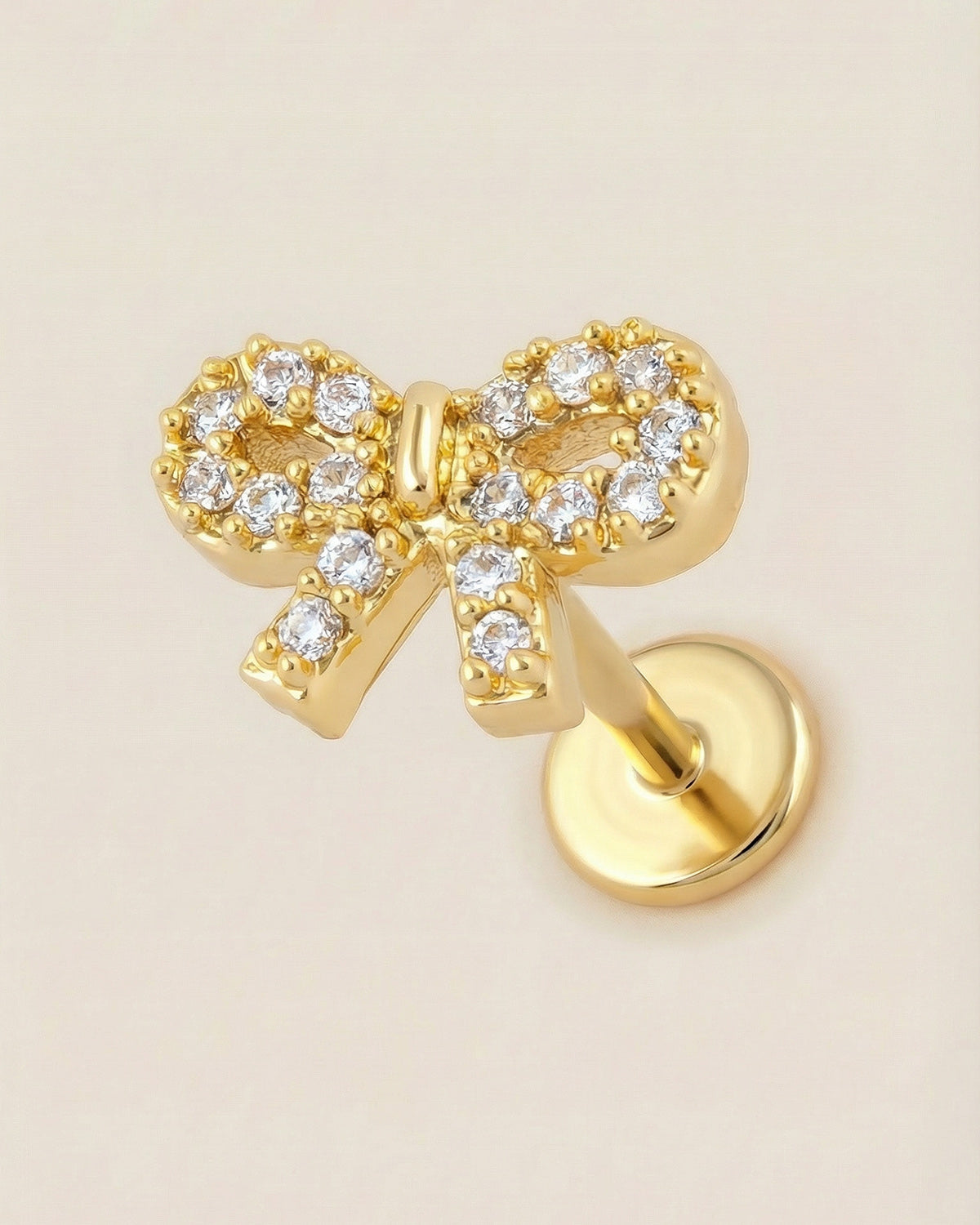Altın renkli 316L cerrahi çelik zirkon taşlı fiyonk flatback piercing tasarımı.