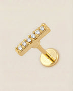 Altın renkli 316L cerrahi çelik zirkon taşlı minimal bar flatback piercing tasarımı.
