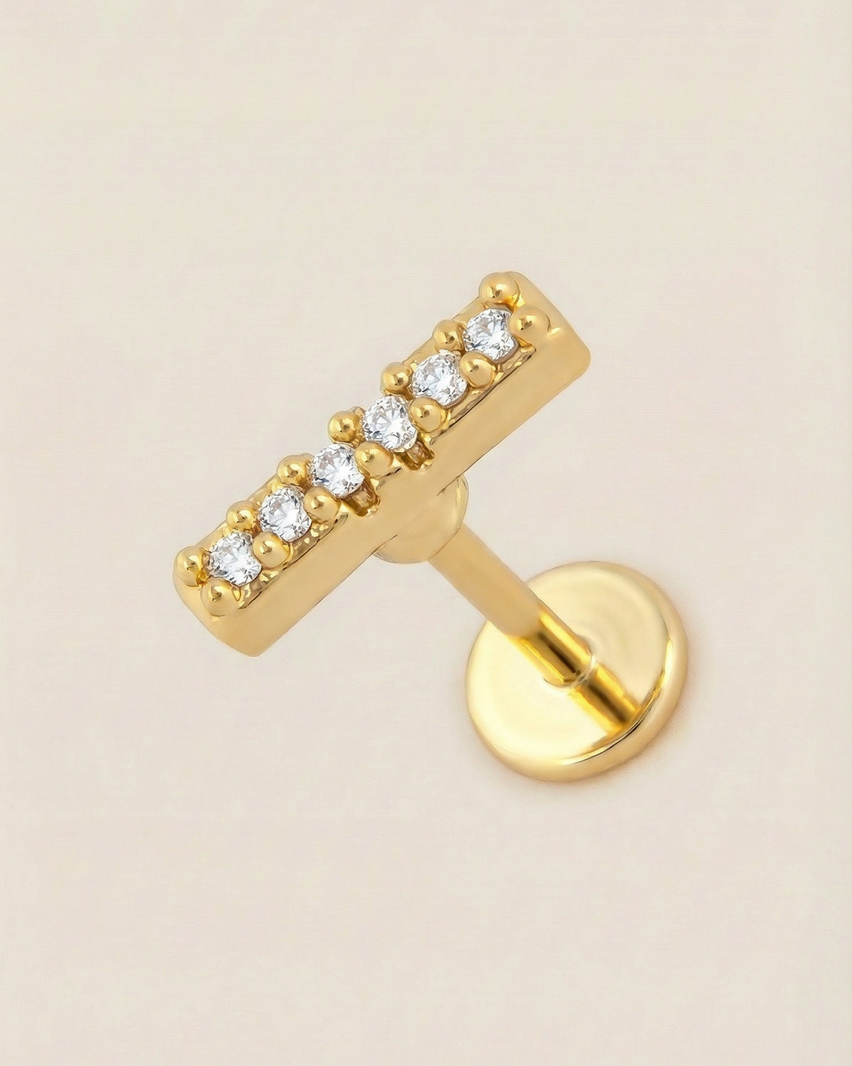 Altın renkli 316L cerrahi çelik zirkon taşlı minimal bar flatback piercing tasarımı.