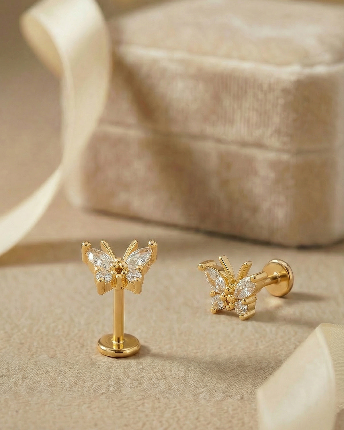 Işıltılı kelebek detaylı altın renkli cerrahi çelik piercing koleksiyonu.