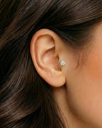 Altın renkli zirkon tektaş piercingin tragus ve kulakta duruşu.
