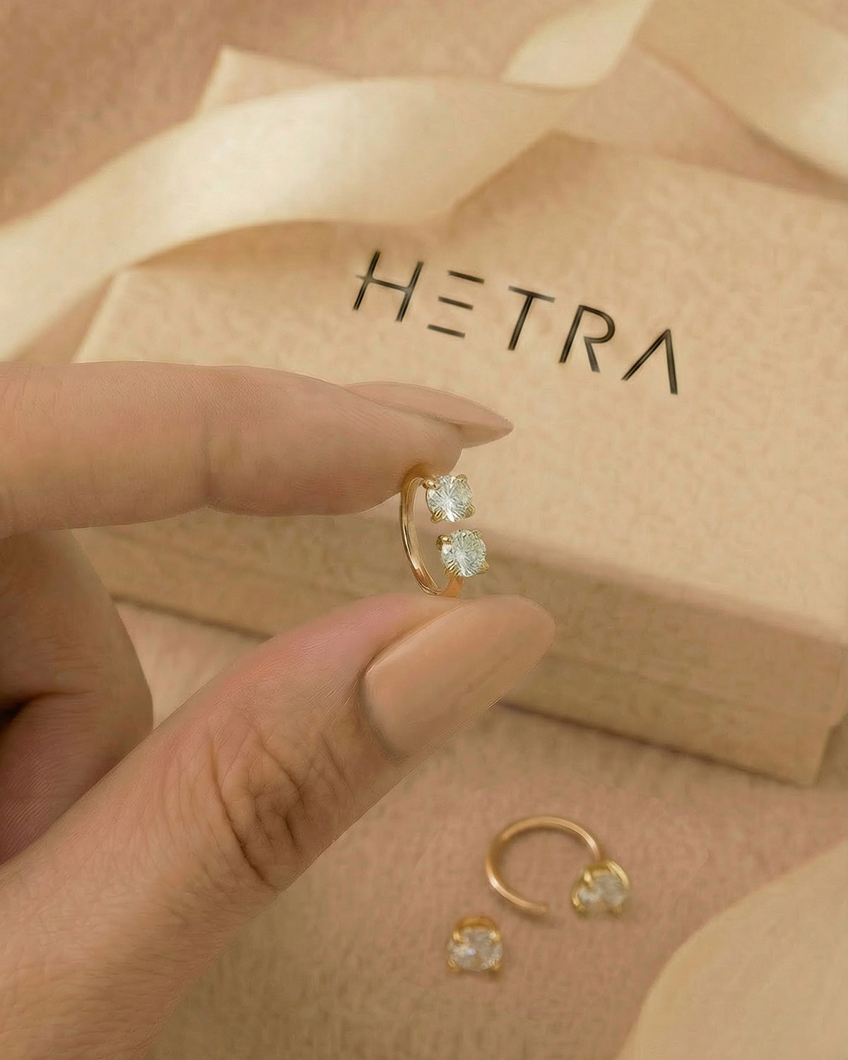 Altın renkli 316L cerrahi çelik 6 mm çift tektaş yarım halka piercing tasarımın elde duruşu.