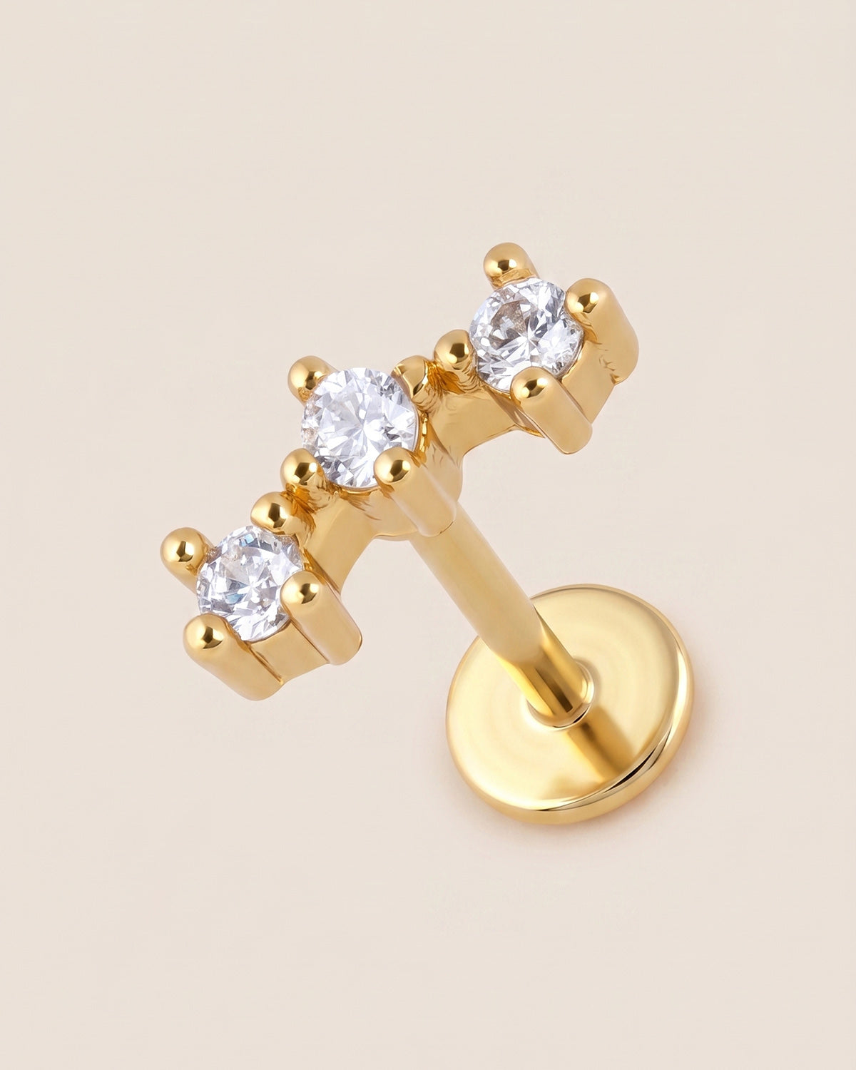 Altın renkli 316L cerrahi çelik kavisli 3 taşlı flatback piercing tasarımı.