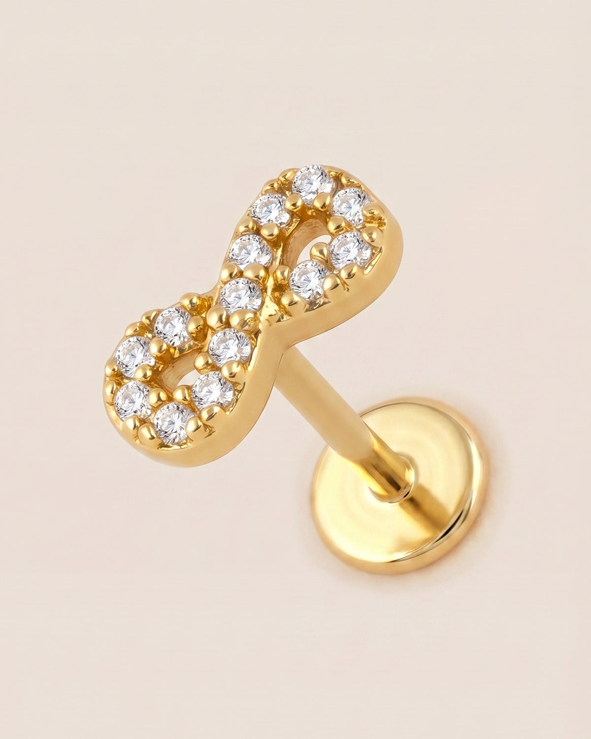 Altın renkli 316L cerrahi çelik sonsuzluk figürlü flatback piercing tasarımı.