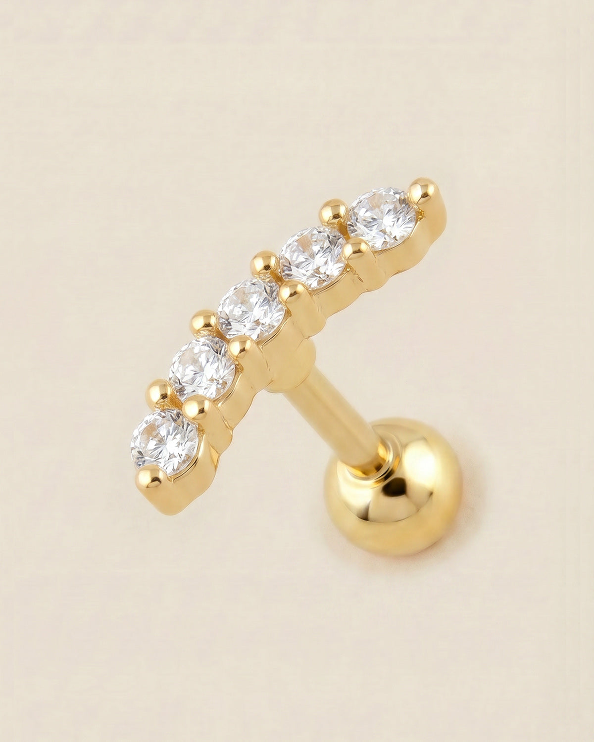 Altın renkli cerrahi çelik zirkon taşlı kavisli tragus piercing tasarımı.
