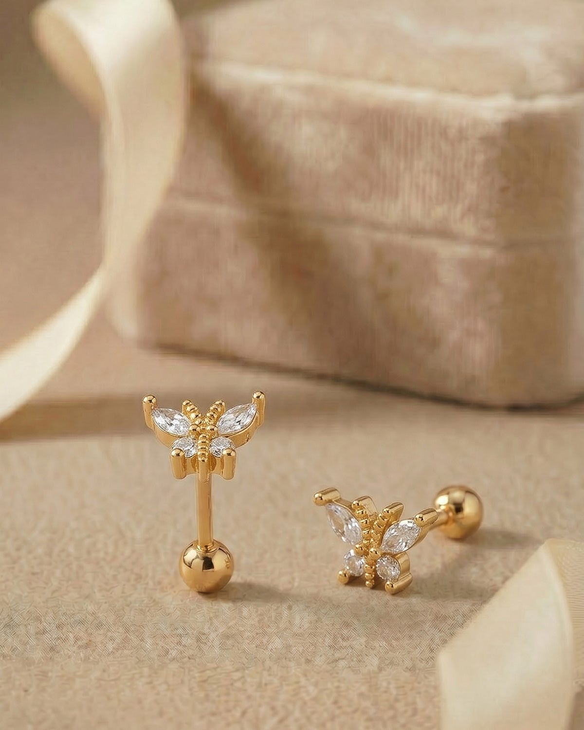 Altın renkli zirkon taşlı kelebek figürlü tragus piercingin koleksiyon görünümü.