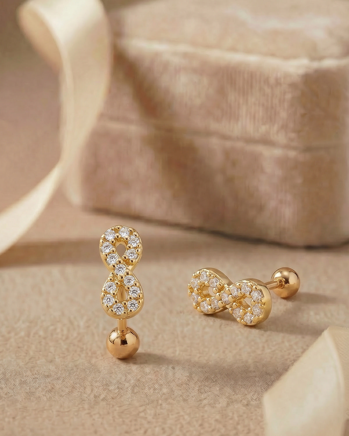 Altın renkli zirkon taşlı sonsuzluk figürlü tragus piercingin koleksiyon görünümü.