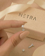 Gümüş renkli 316L cerrahi çelik 6 mm toplu flatback tragus piercing tasarımın elde duruşu.