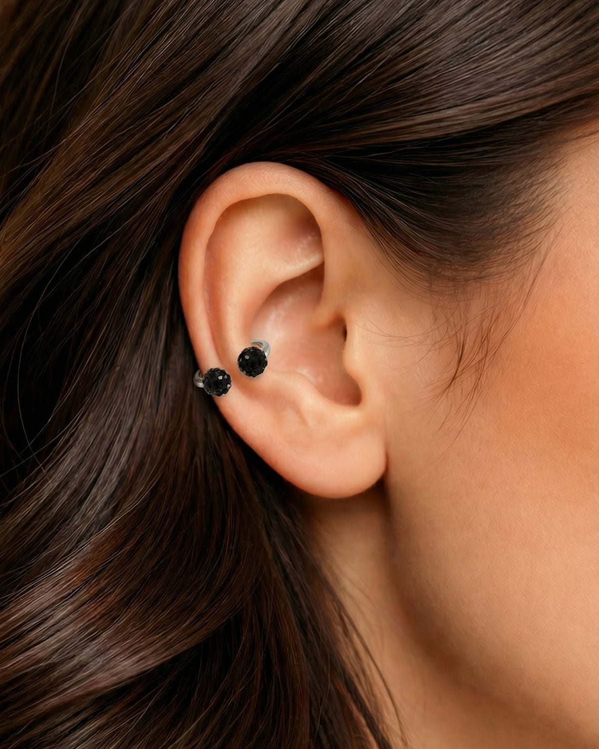 Gümüş renkli siyah toplu 8 mm zirkon taşlı yarım halka piercingin helix ve kıkırdakta duruşu.