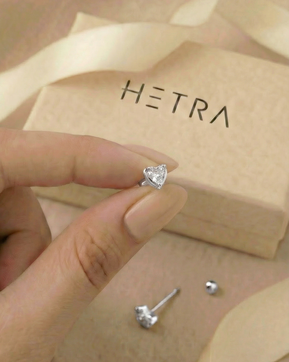 Minimal kalp zirkon taşlı gümüş renkli tragus piercingin elde gerçek boyutu.