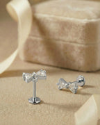 Özel üçgen kesim taşlı kurdele figürlü gümüş renkli cerrahi çelik piercing.