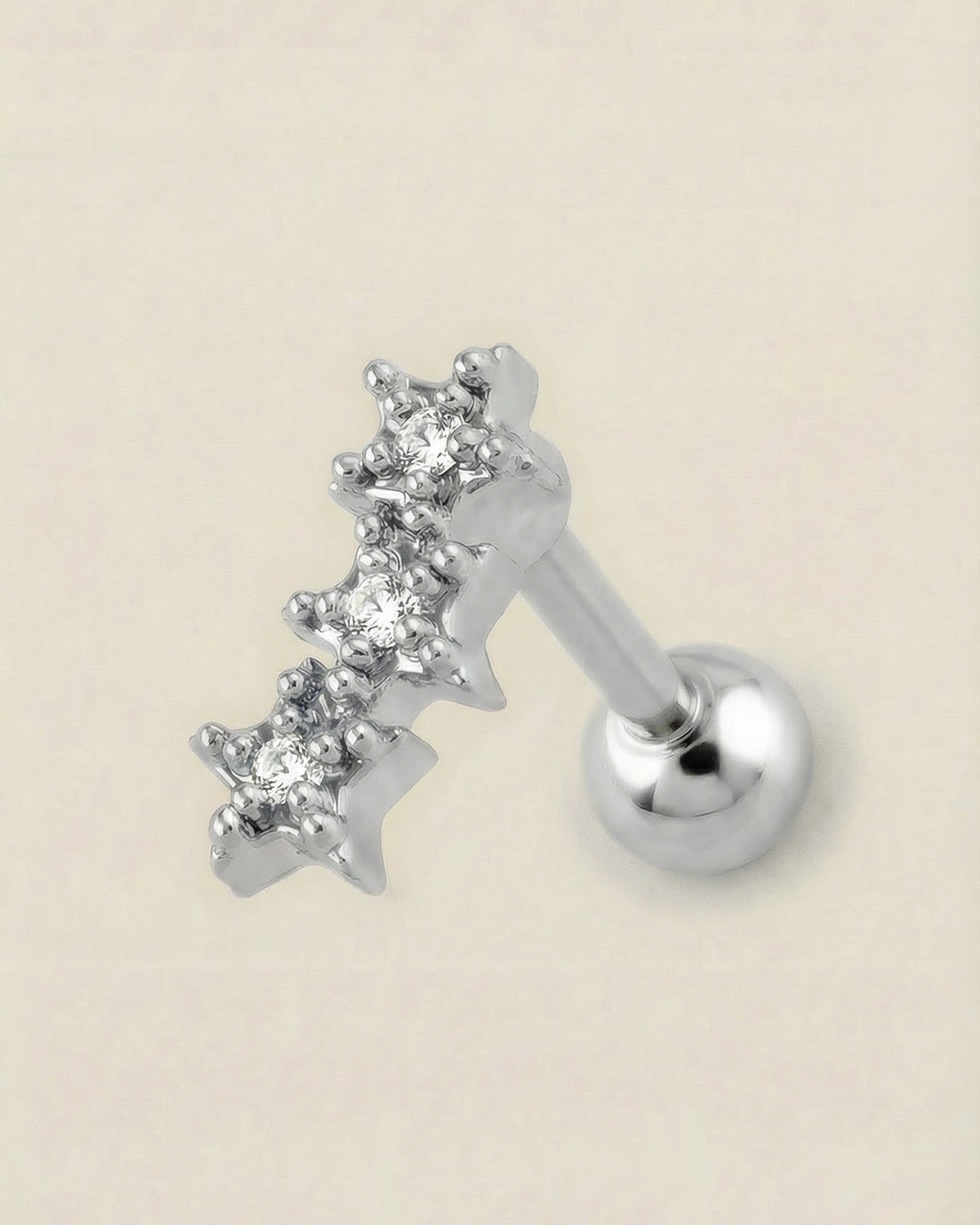 Gümüş renkli 316L cerrahi çelik üçlü yıldız formlu zirkon taşlı tragus piercing tasarımı.