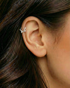 Gümüş renkli yıldız formlu zirkon taşlı halka piercingin helix ve kıkırdak bölgesinde duruşu.