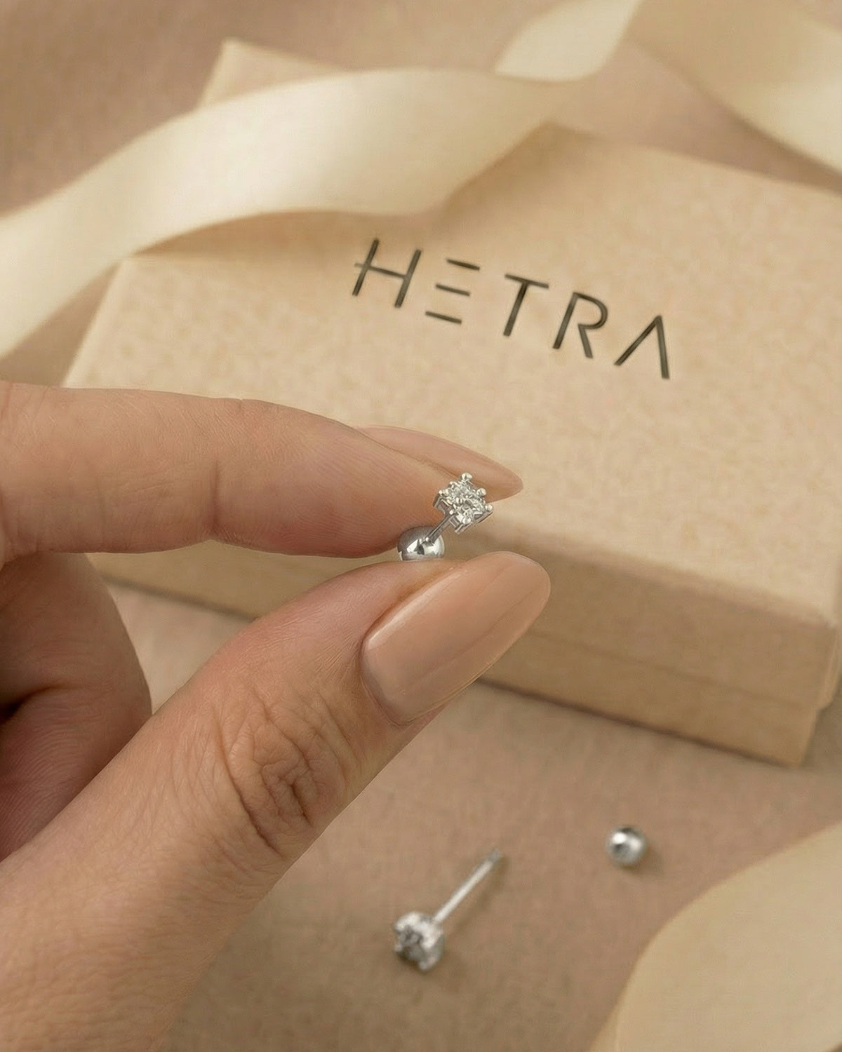 Zirkon dört taşlı yonca gümüş renkli tragus piercingin elde gerçek boyutu.