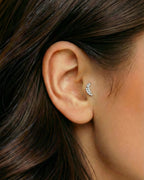 Gümüş renkli zirkon taşlı kavisli piercingin tragus ve helix bölgesinde duruşu.