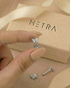 Gümüş renkli zirkon taşlı minimal kelebek flatback piercingin elde gerçek boyutu.