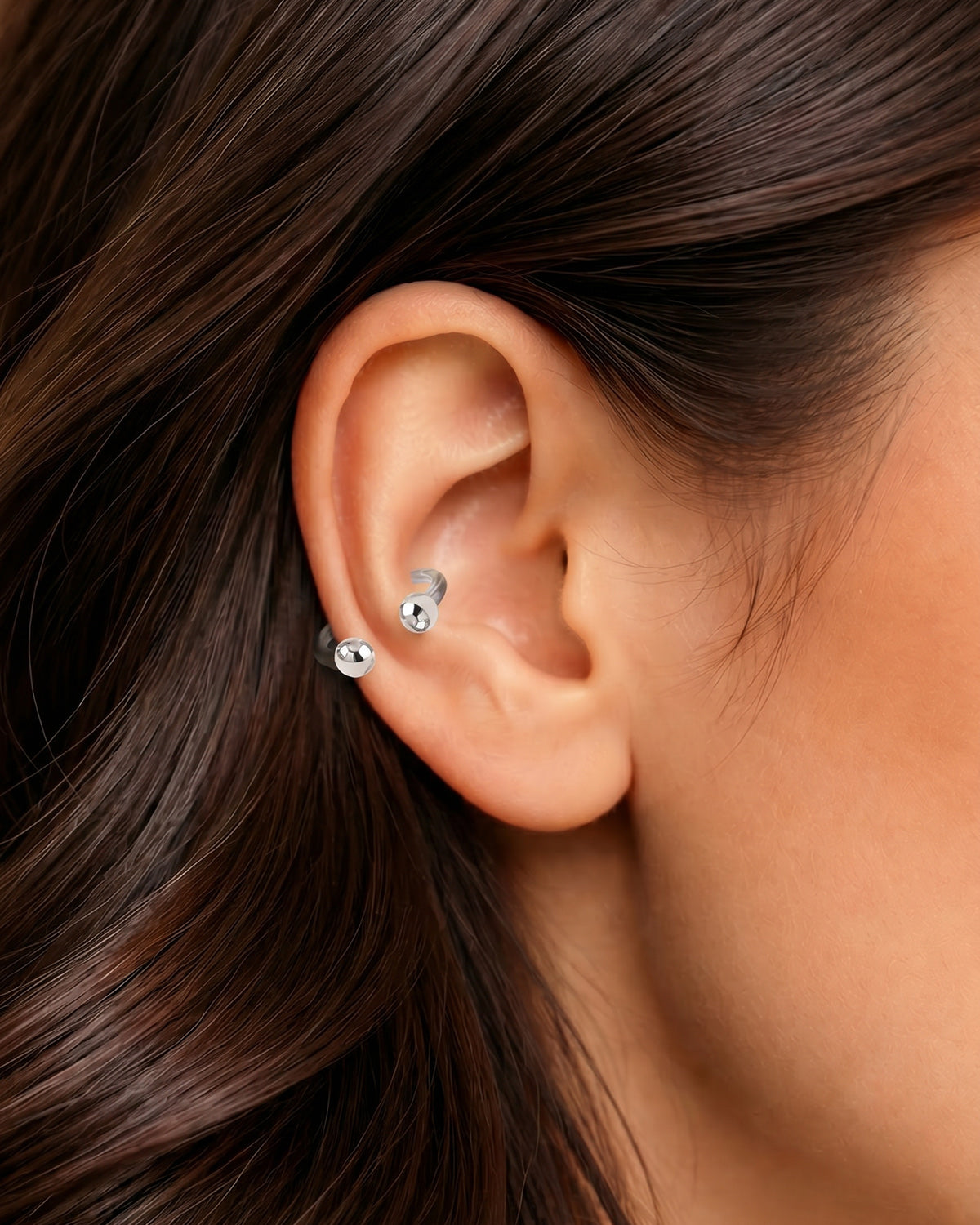 Gümüş renkli yarım halka piercingin helix ve kıkırdak bölgesindeki duruşu.