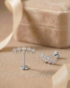 Gümüş renkli kavisli 5 zirkon taşlı flatback piercingin koleksiyon görünümü.