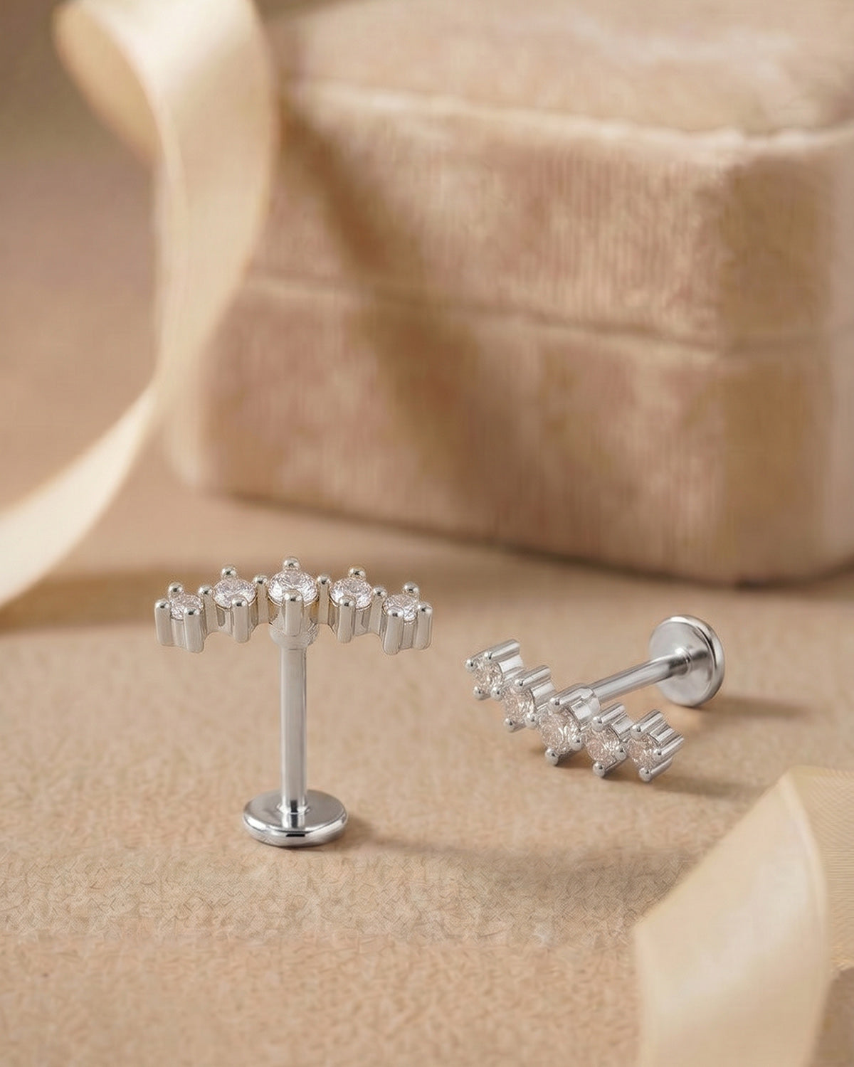 Gümüş renkli kavisli 5 zirkon taşlı flatback piercingin koleksiyon görünümü.