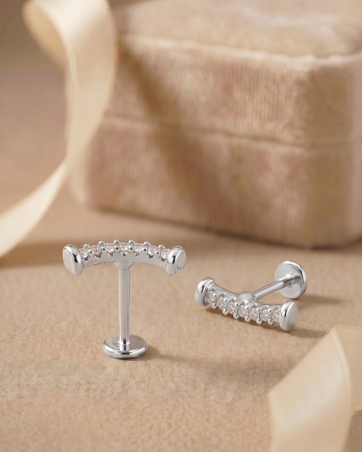 Gümüş renkli kavisli flatback piercingin koleksiyon görünümü.