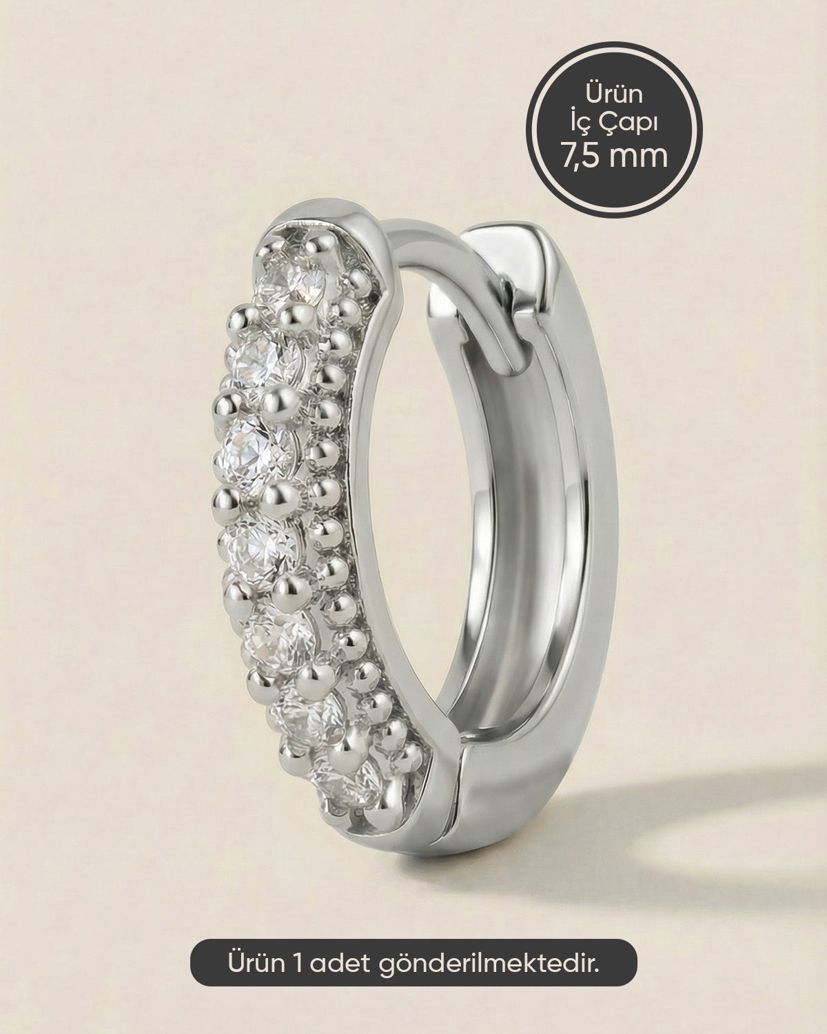 Gümüş renkli 316L cerrahi çelik kenarı topçuk detaylı zirkon taşlı halka piercing tasarımı.