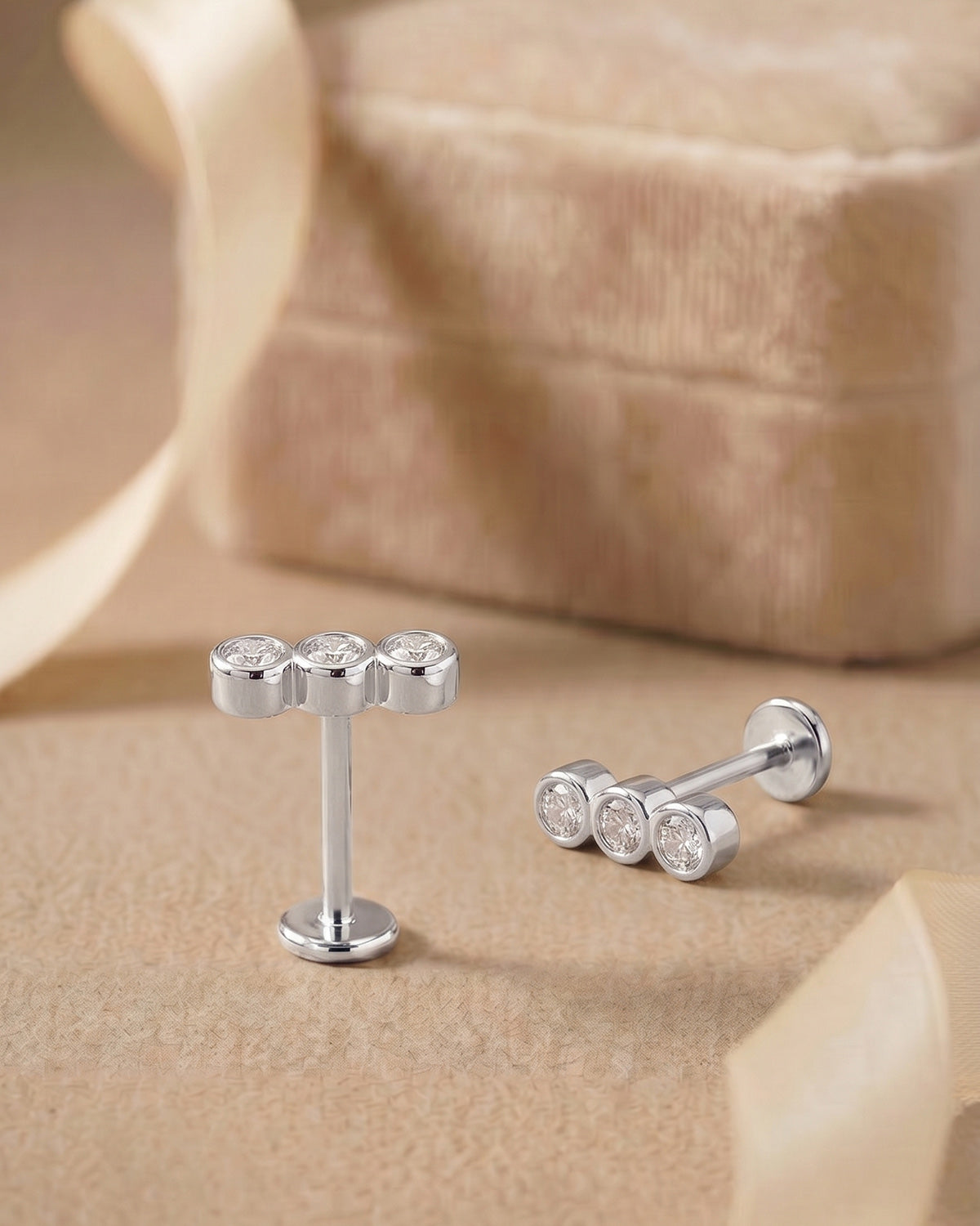 Gümüş renkli sıralı 3 taşlı flatback piercingin koleksiyon görünümü.