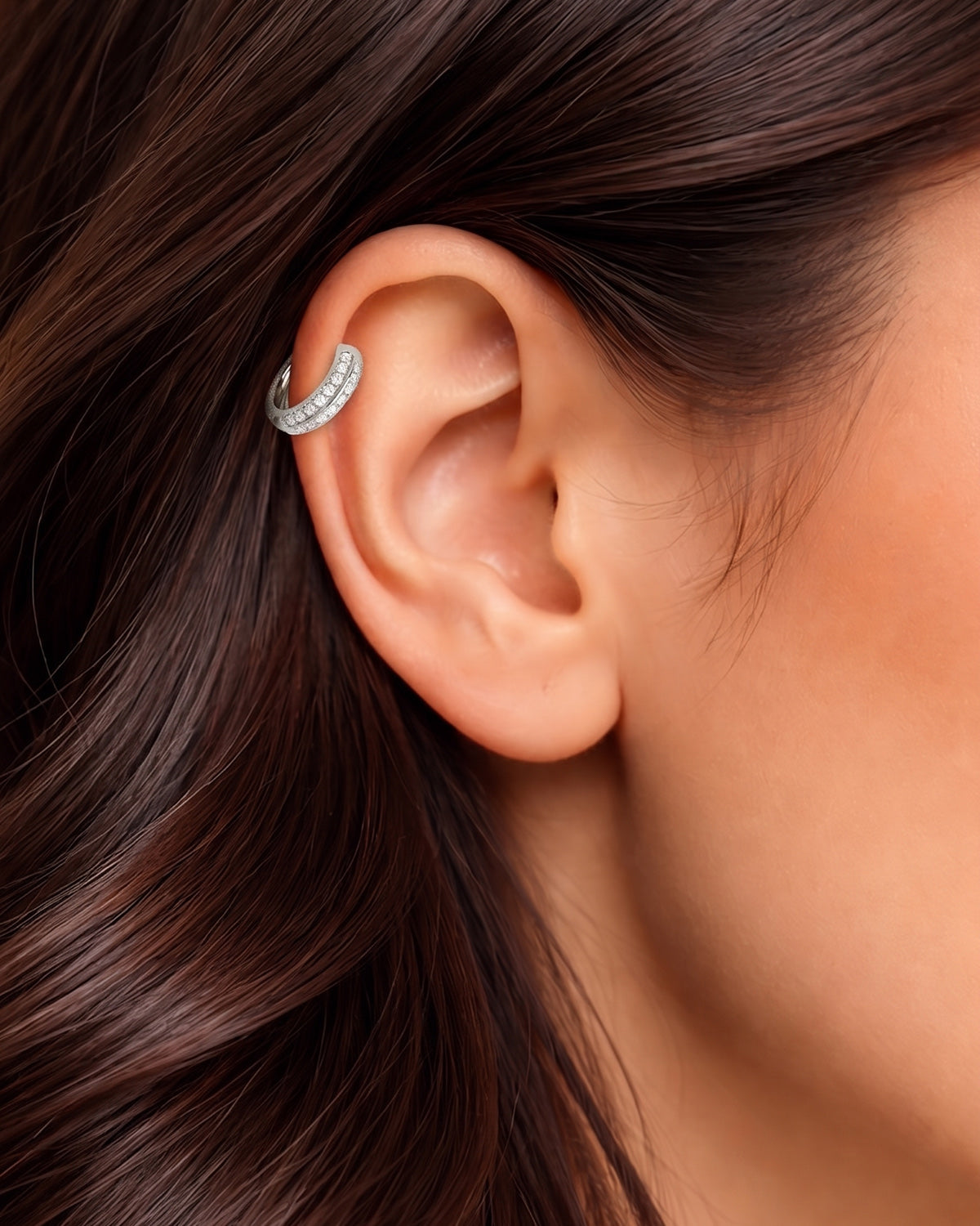 Gümüş renkli çift sıra zirkon taşlı halka piercingin helix ve kıkırdak bölgesindeki duruşu.