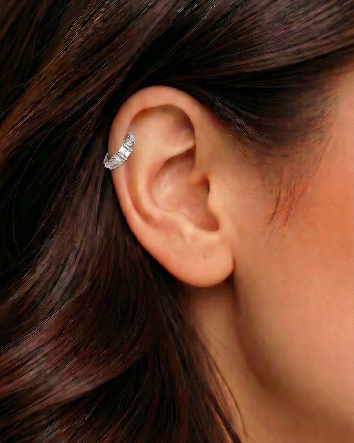 Gümüş renkli dikdörtgen taşlı halka piercingin helix ve kıkırdak bölgesindeki duruşu.