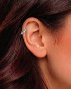 Gümüş renkli taşsız bambu formlu halka piercingin helix ve kıkırdak bölgesindeki duruşu.