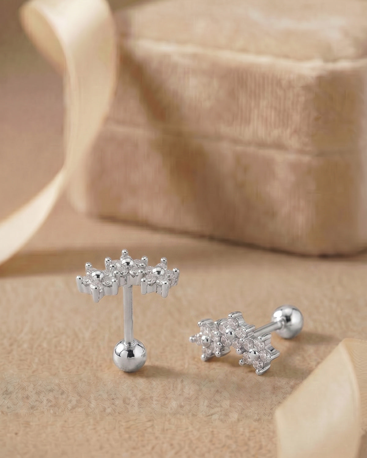 Gümüş renkli zirkon taşlı kavisli çiçekli tragus piercingin koleksiyon görünümü.
