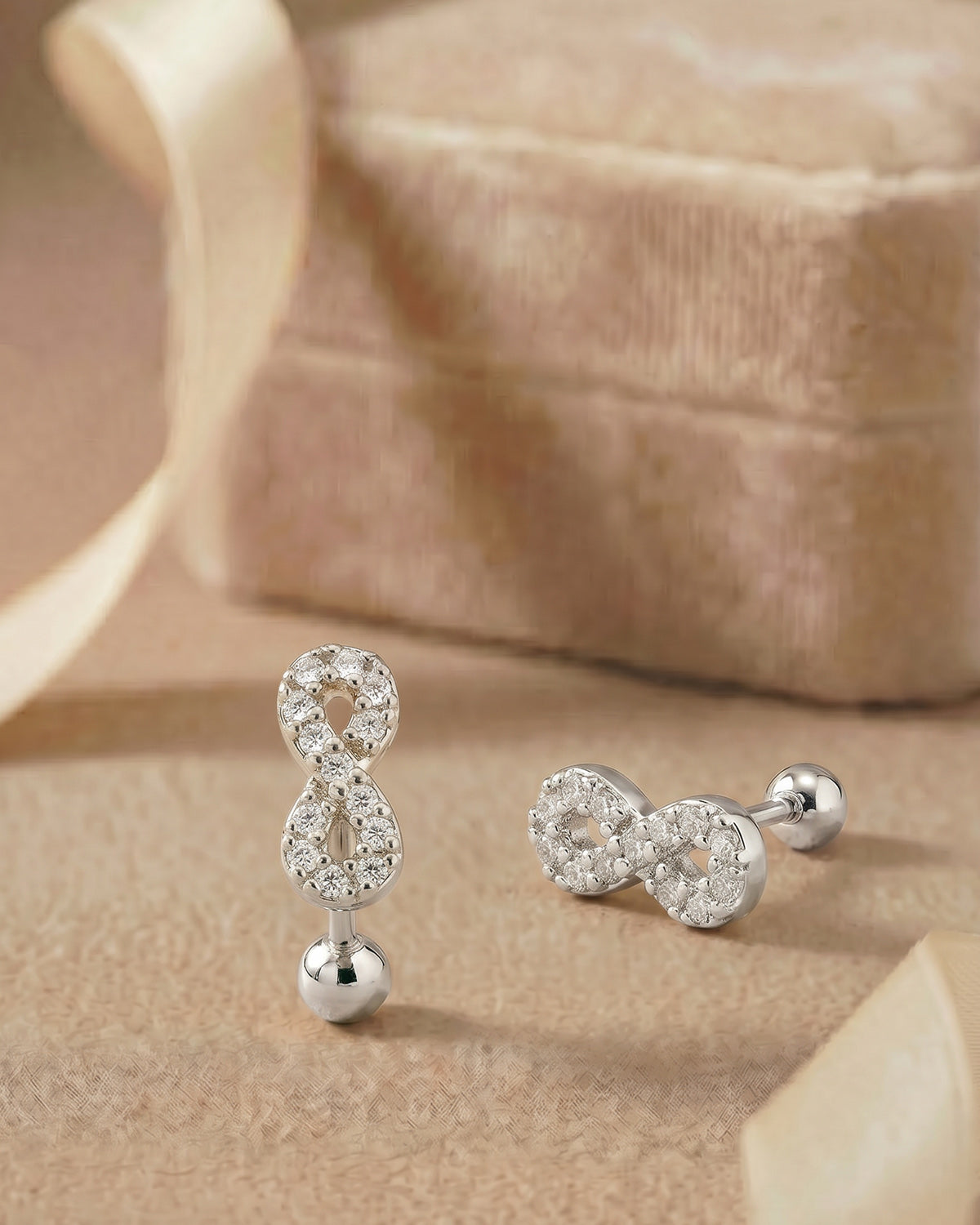 Gümüş renkli zirkon taşlı sonsuzluk figürlü tragus piercingin koleksiyon görünümü.